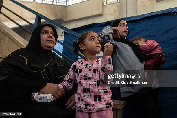 Refugee family from South Lebanon eat cookies in the Camille Chamoun Sports City Stadium hallways where tents were provided by the Lebanese Red Cross...