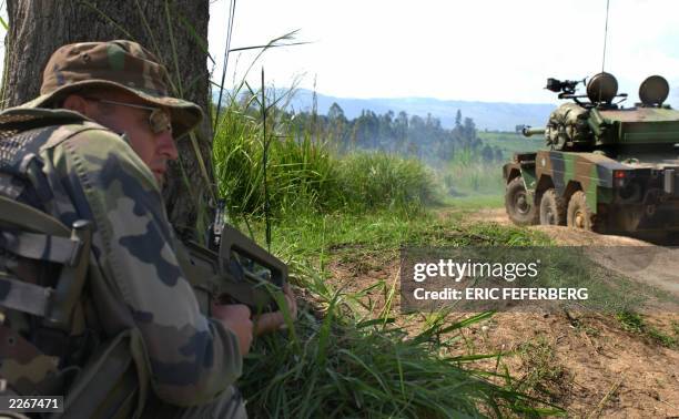 French special forces soldier takes cover as a light "Sagaie" tank returns fire from militiamen 14 June 2003 in Bunia. In the nearby village of Chai,...