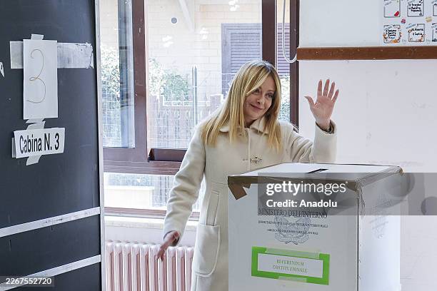 Italian Premier Giorgia Meloni waves after voting in a constitutional referendum on a reform of the Italian judicial system at a polling station in...