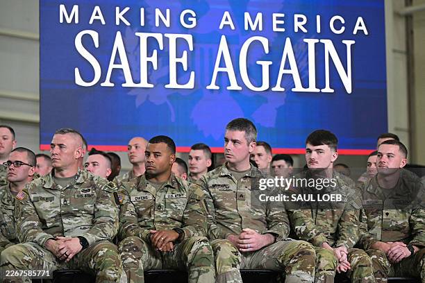 Members of the US military listen as President Donald Trump speaks during the Memphis Safe Task Force roundtable in Memphis, Tennessee on March 23,...