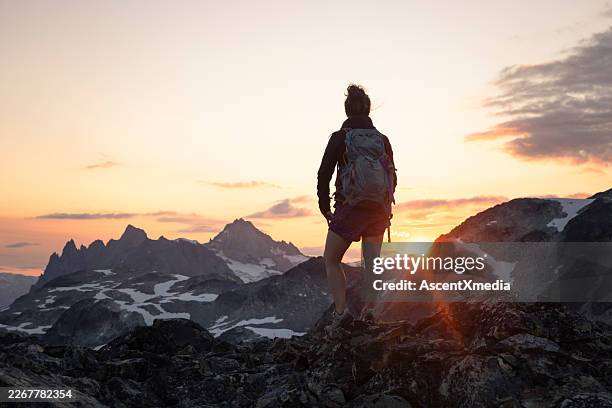 woman watches sunset over glaciated mountains, b.c. - golden hour stock pictures, royalty-free photos & images