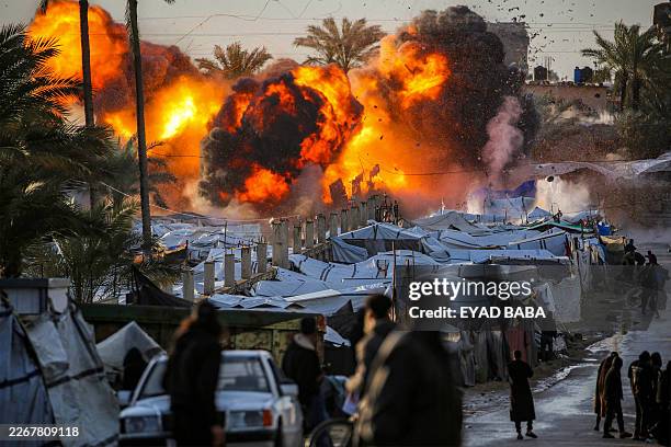 Fireball erupts following an Israeli strike near a tent encampment sheltering people displaced by war in Deir el-Balah in the central Gaza Strip on...