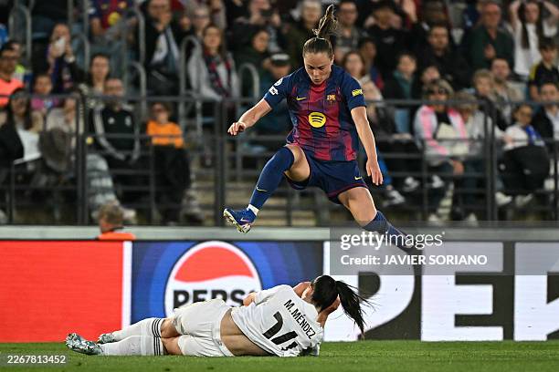 Barcelona's Spanish midfielder Clara Serrajordi jumps over Real Madrid's Spanish defender Maria Mendez during the UEFA Women's Champions League...