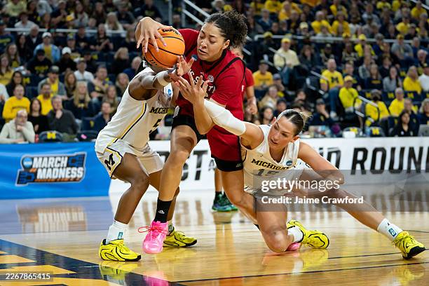 Khamil Pierre of the NC State Wolfpack battles for a loose ball against Brooke Quarles Daniels and Ashley Sofilkanich of the Michigan Wolverines...