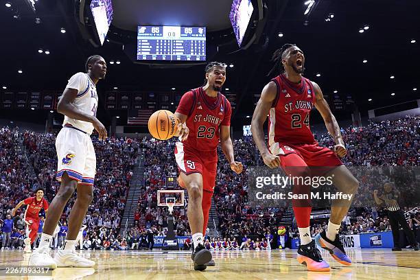 Flory Bidunga of the Kansas Jayhawks reacts as Bryce Hopkins and Zuby Ejiofor of the St. John's Red Storm celebrate a 67-65 victory after the game in...