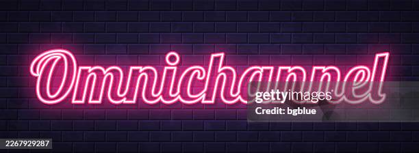 omnichannel - glowing neon text on brick wall background - omnichannel stock illustrations