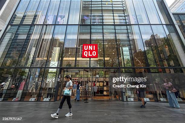 Pedestrians walk past a Uniqlo retail store on March 23, 2026 in Shenzhen, Guangdong province, China. Japanese apparel retailer Uniqlo continues to...