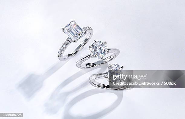 three elegant diamond engagement rings on a pristine white surface, captured with a high-angle view - diamond ring stock pictures, royalty-free photos & images