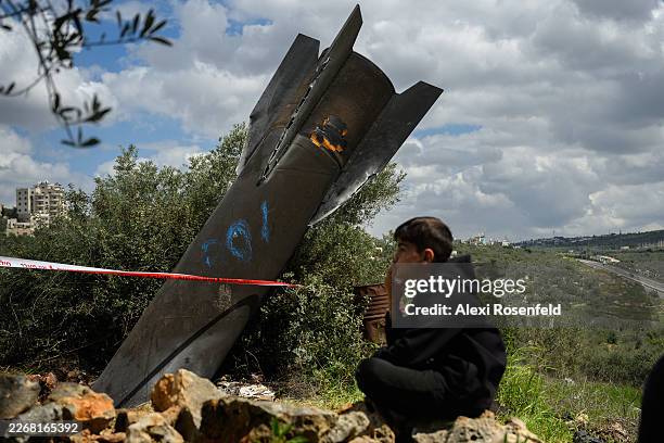 Palestinian civilians gather near an Iranian missile embedded in the ground on March 24, 2026 in Hares, West Bank. Iranian missiles have routinely...