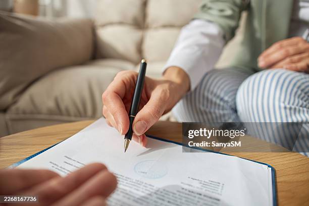 adult hand signing agreement document with pen at home - notary stock pictures, royalty-free photos & images