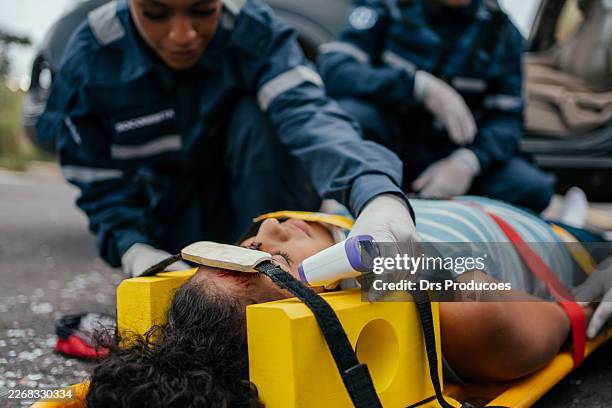 paramedics checking the temperature and oxygen saturation of a car accident victim. - casualty stock pictures, royalty-free photos & images