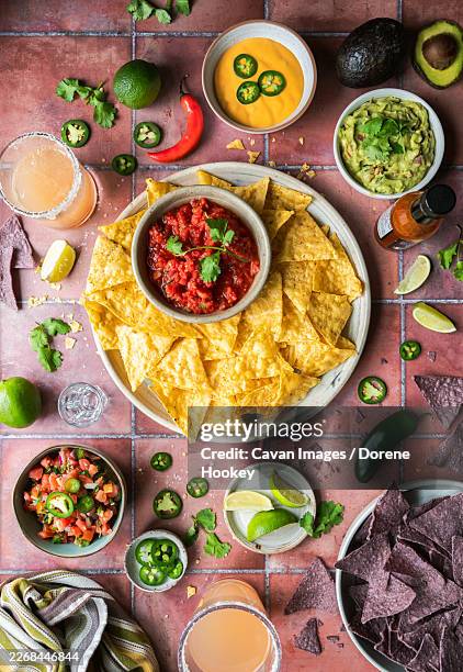 top view tortilla chips, salsa, guacamole, queso and drinks on tile - queso dip stock pictures, royalty-free photos & images