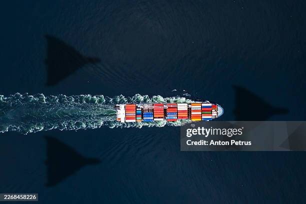 cargo ship and heavy kamikaze drones silhouettes - stretto foto e immagini stock