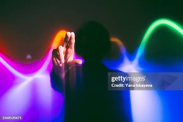 silhouette interacting with colorful ai waveform and digital signal interface - human aura stock pictures, royalty-free photos & images