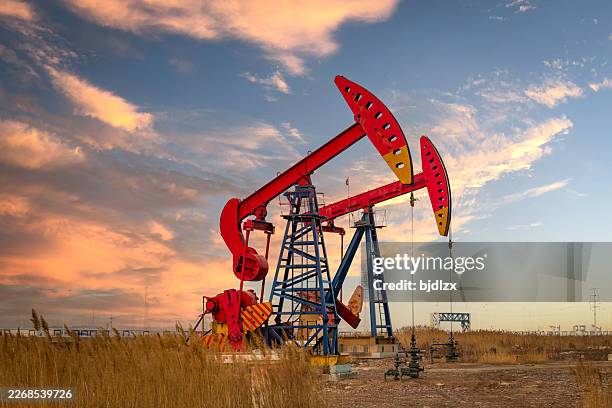 the pumping unit under the sunset in the oil field - pump jack stock pictures, royalty-free photos & images