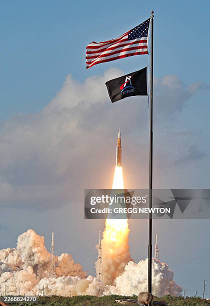 And Artemis flag are seen as the Artemis II crewed lunar mission lifts off from Pad 39B at Kennedy Space Center in Cape Canaveral, Florida, on April...