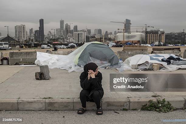 Woman sits on a pavement by a tent as displaced families struggle for survival in the streets of Beirut, Lebanon, on April 2, 2026. Following nearly...
