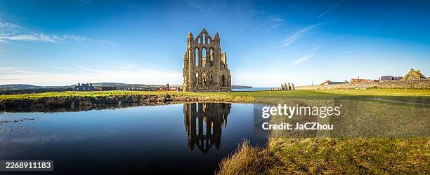 ruines de l’abbaye de whitby reflétées dans l’eau, côte du north yorkshire, royaume-uni - archéologie photos et images de collection
