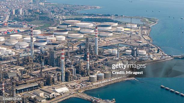 oil refinery and industrial complex on coastline with storage tanks - complexity stock pictures, royalty-free photos & images