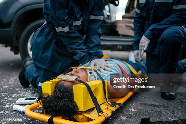 paramedics checking the temperature and oxygen saturation of a car accident victim. - casualty stock pictures, royalty-free photos & images