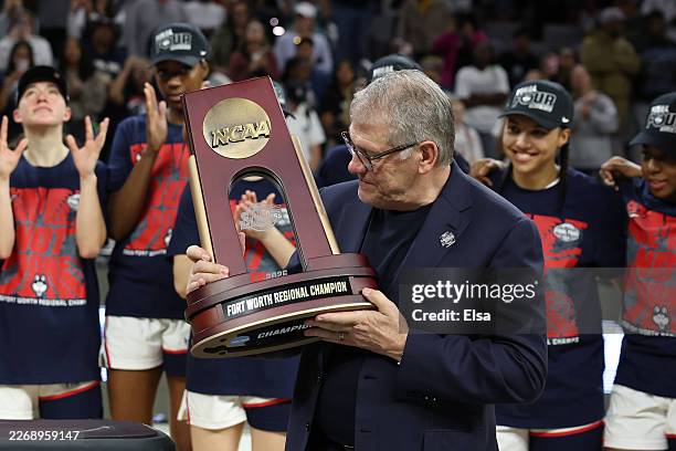 Head coach Geno Auriemma of the UConn Huskies holds the Fort Worth Regional Trophy after defeating the Notre Dame Fighting Irish 70-52 in the Elite...