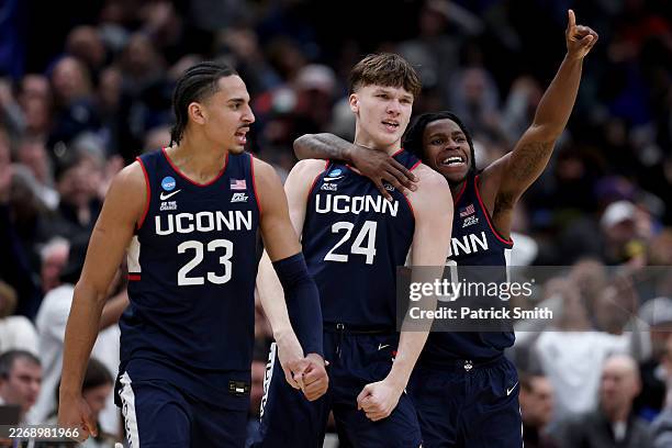 Braylon Mullins celebrates with Jayden Ross and Malachi Smith of the UConn Huskies after Mullins shot the game-winning three point basket during the...