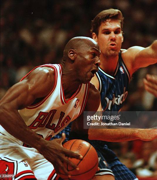 Guard Michael Jordan drives to the basket past forward Jon Koncak of the Orlando Magic during the third quarter of action in game two of the NBA...