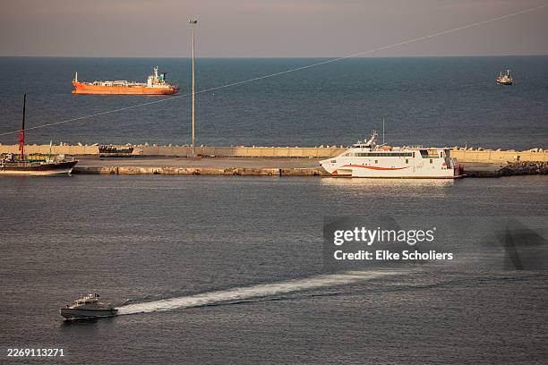 Police speed boat patrols the port as oil tankers and high speed crafts sit anchored at Muscat Anchorage near the Strait of Hormuz on March 30, 2026...