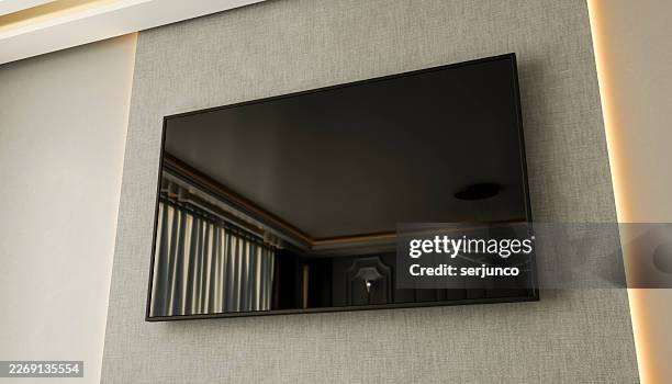 modern flat-screen tv mounted on a textured wall with a minimalistic design. illustration, rendering - looking at screen reflection stock illustrations