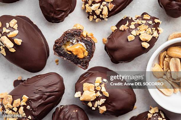 delicious peanut butter stuffed dates sweets with chocolate and peanuts - stuffed stock pictures, royalty-free photos & images