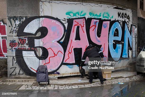 Man places a computer monitor near a wall with graffiti reading ''Zachem'' at the intersection of Mihaila Bogicevica and Karadjordjevica streets in...