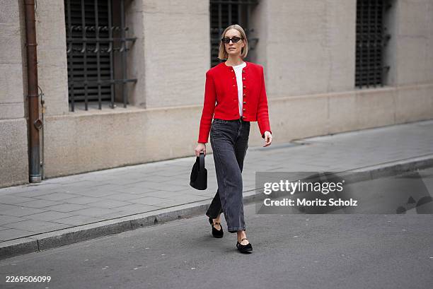 Marlies Pia Pfeifhofer is seen wearing a red knit "Janker" cardigan featuring decorative silver buttons from La Foresta; a white cotton short sleeve...