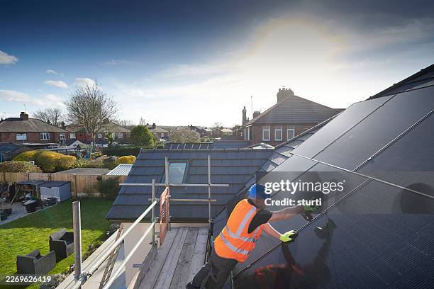 solar panel engineer fitting roof panels - solar panel stock pictures, royalty-free photos & images
