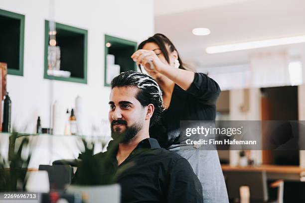 barber styling man's hair in professional hairdresser shop - man hair care stock pictures, royalty-free photos & images
