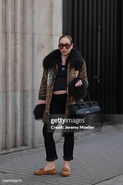 Sonia Lyson is seen wearing a bold leopard print Charlotte Simone jacket with a shaggy black fur collar and cuffs, featuring a strip of pink and...