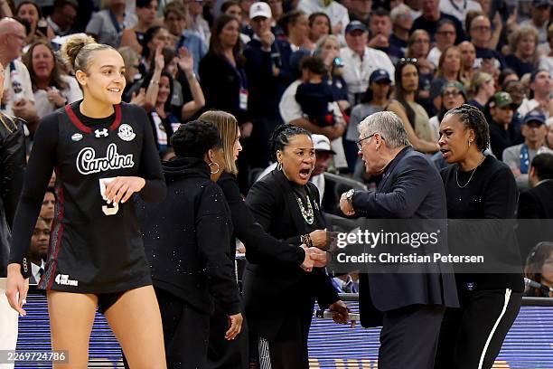 Head coach Dawn Staley of the South Carolina Gamecocks and head coach Geno Auriemma of the UConn Huskies exchange words during the fourth quarter in...