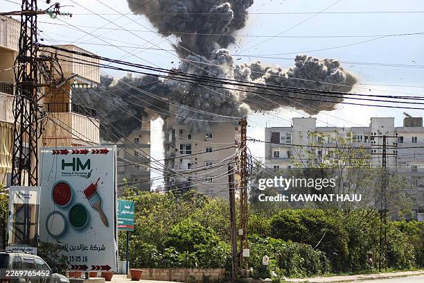 Smoke and debris rise after a building is hit by an Israeli airstrike in the area of Abbasiyeh, on the outskirts of the southern Lebanese city of...
