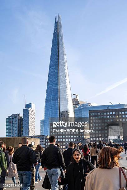 Crowds of people head home from offices in the financial district, with The Shard visible in the background.