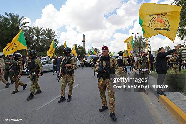 Members of Iraq's pro-Iran paramilitary group Hezbollah Brigades gather in a mourning procession for one of their comrades who was killed the...