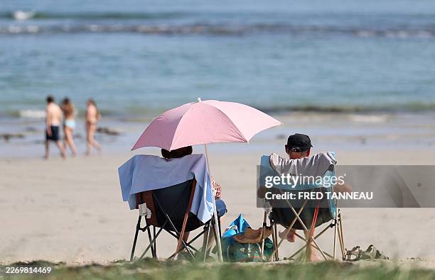 People sit on a beach April 8, 2026 in Combrit, western France.
