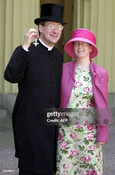 The Vicar at St Andrew's Church in Soham, Cambridgeshire, the Reverend Timothy Alban Jones, stands with his wife Cathy after becoming an MBE at...