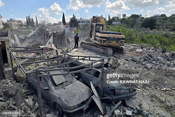 Rescuers search under the rubble at the site of an Israeli airstrike that targeted a house in Abbassiyeh on the outkirts of the southern Lebanese...