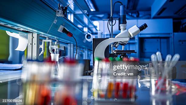 di un laboratorio moderno con microscopio e provette colorate - ricerca scientifica foto e immagini stock