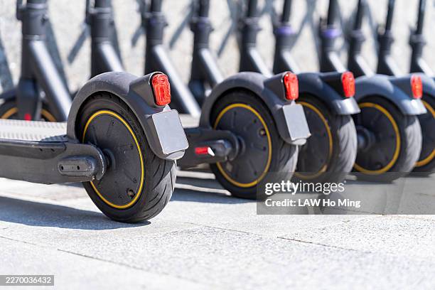 shared electric scooters parked in a row - elektrische step stockfoto's en -beelden