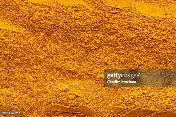 turmeric powder background and texture, macro shot - turmeric stock pictures, royalty-free photos & images