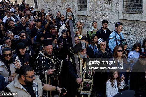 April 2026, ---, Jerusalem: Greek Orthodox Patriarch of Jerusalem Theophilos III carries a cross as he takes part in the Good Friday Procession in...