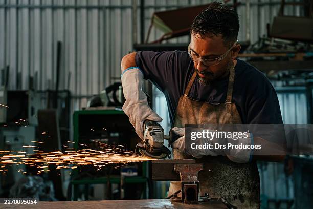 metalworker sanding metal with an angle grinder. - metaalbewerking stockfoto's en -beelden