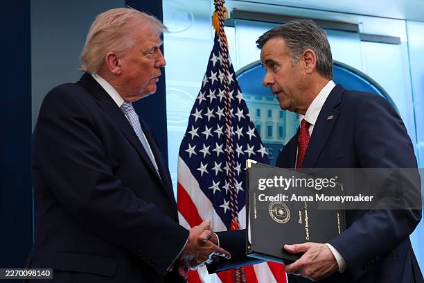 President Donald Trump shakes hands with CIA Director John L. Ratcliffe during a news conference in James S. Brady Press Briefing Room of the White...