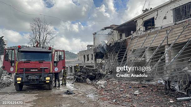 Civil defense and firefighting teams carry out operations on a damaged building as 8 security personnel lost their lives in Israeli airstrikes on the...
