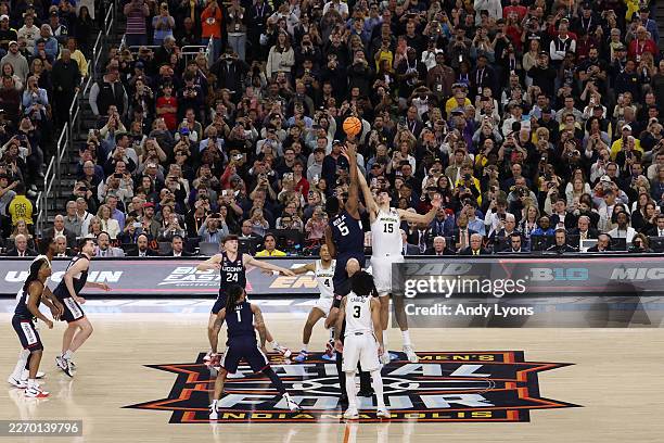 Aday Mara of the Michigan Wolverines and Tarris Reed Jr. #5 of the UConn Huskies take the tip off during the first half of a game in the National...